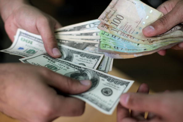 People exchange US dollars and Venezuela