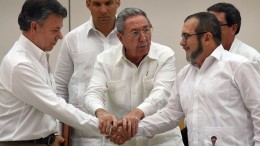 Raul Castro seals the handshake between the head of the FARC, Timochenko, and the Colombian President, Juan Manuel Santos. Photo (c) The Guardian 2016