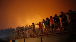 Locals and firemen of damaged town of Santa Olga look on. Photo (c) Reuters 2017